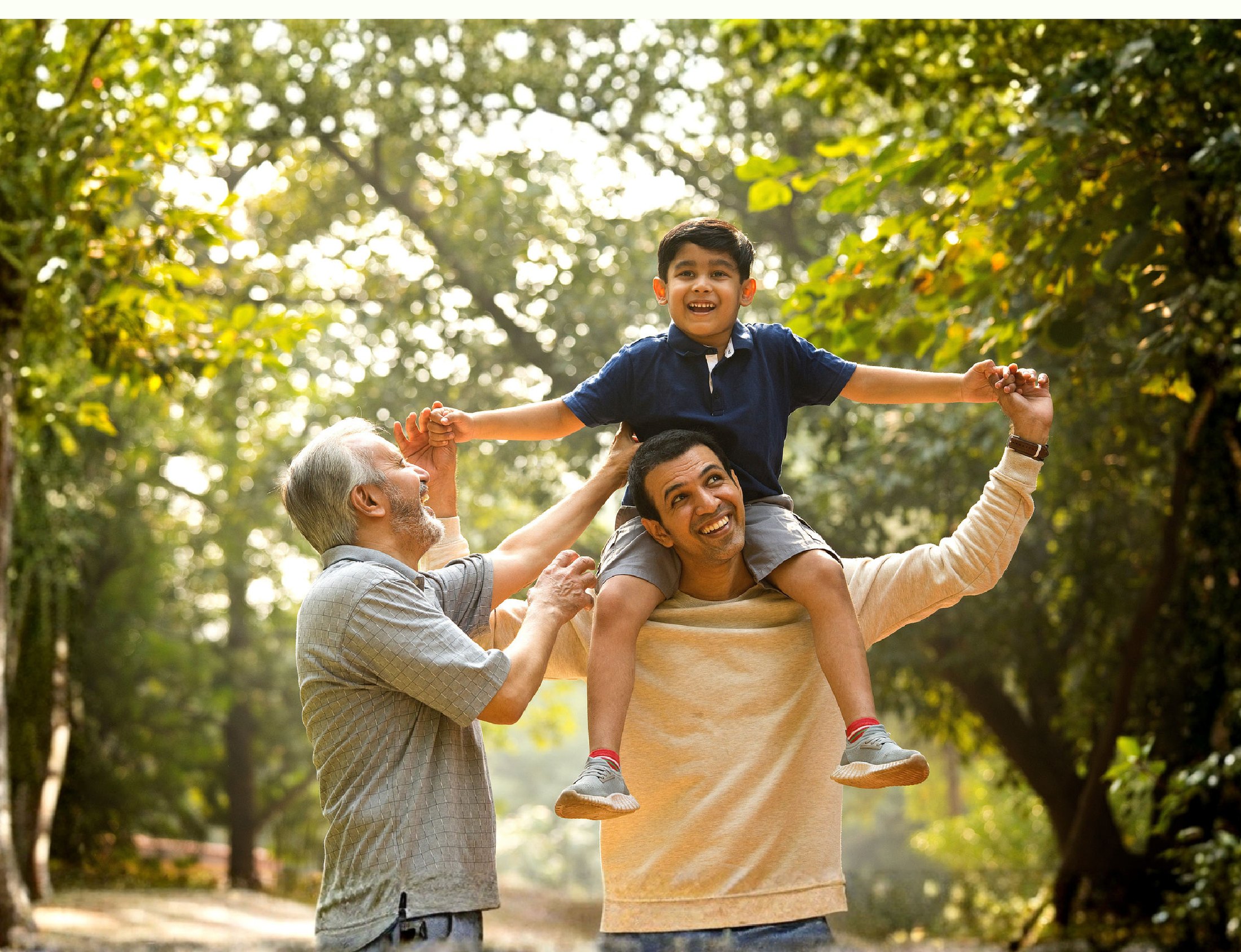 Family walking together along a tree-lined estate path